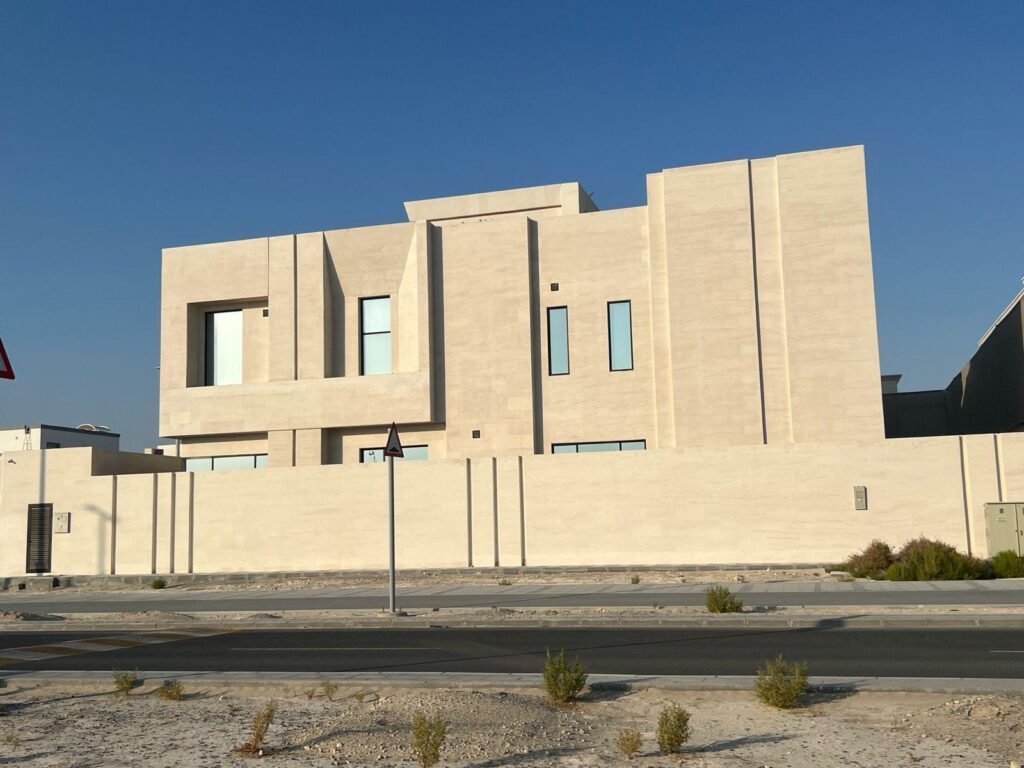Modern villa façade in Moca Cream limestone under Gulf sunlight